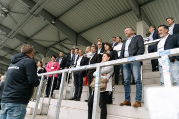 Menschen in Business Kleidung stehen auf der Stadiontribühne